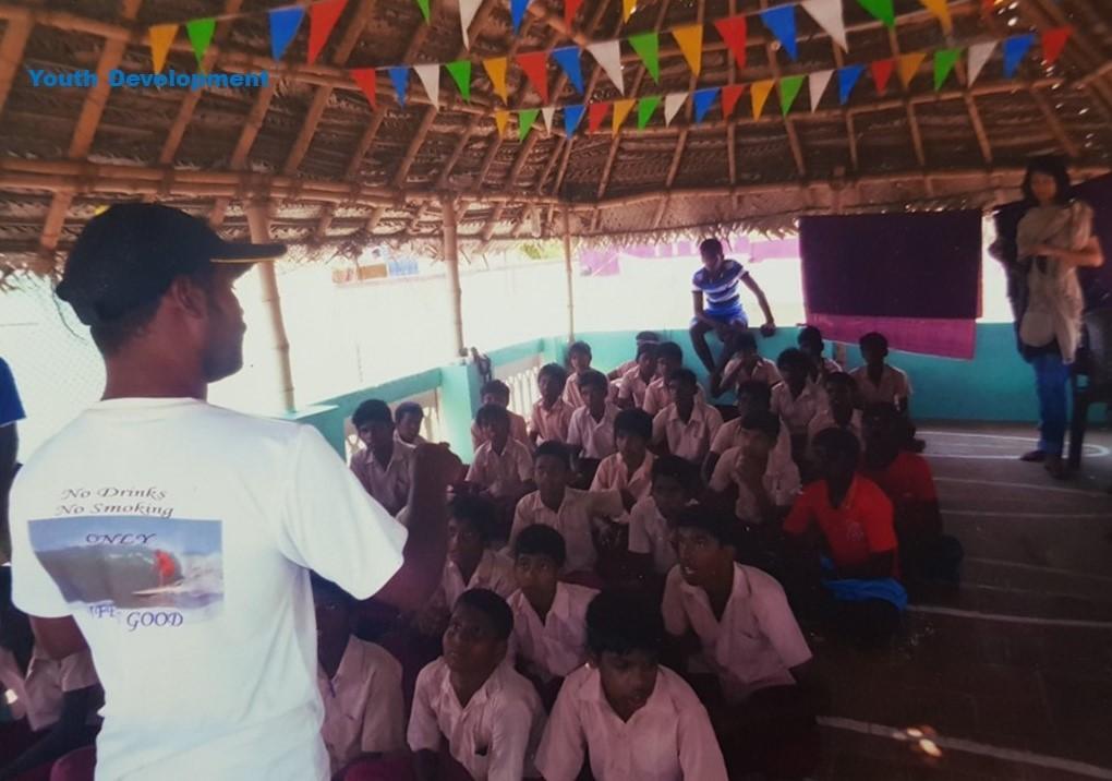 Murthy Megavan speaking to young local boys and girls